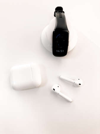 Fitness watches and wireless headphones lie on a beautiful white table.の写真素材