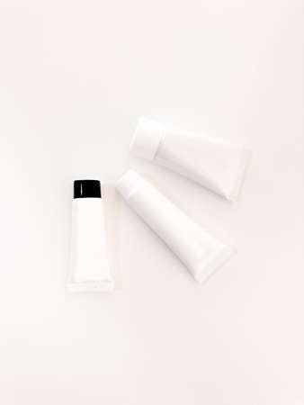 Beautiful tubes on a beautiful white table. No labels. For cosmetics.
