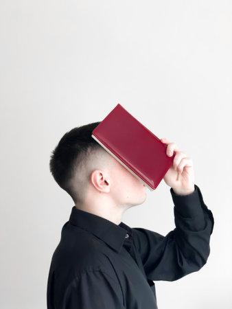 A man with a book in a white room.の写真素材