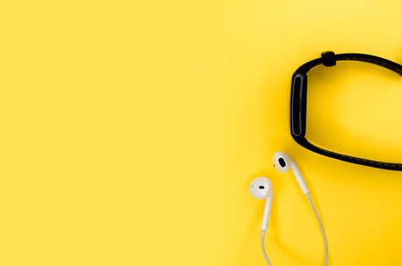 Headphones and smart watches lie on a teble. Minimalist background.の写真素材