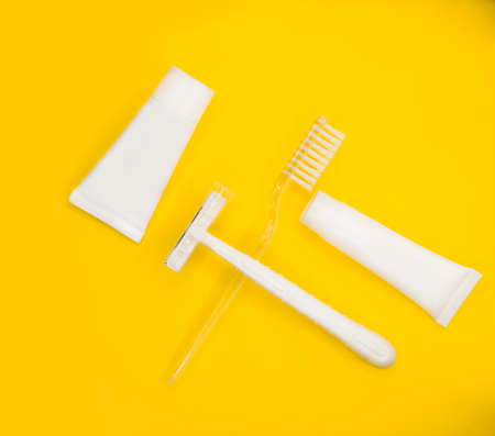 Toothbrush, razor, toothpaste, minimalistic yellow background.の写真素材