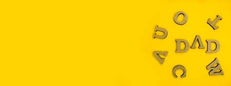 The inscription Dad, on a minimalistic yellow background.の写真素材