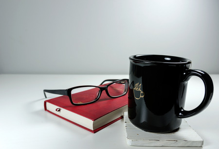 Red book, eyeglasses and a cup of teaの写真素材