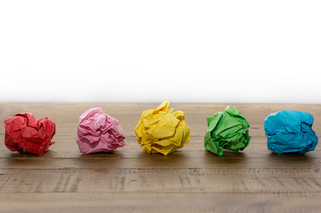 Colorful crumpled paper on a wooden tableの写真素材
