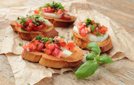 Bruschetta with fresh tomato, cheese and hrebs for breakfastの写真素材