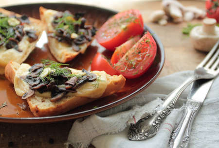 Plate with bruschetta with mushrooms, cheese and garlicの写真素材