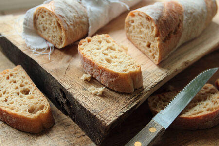 Bread pieces on a wooden board with knife