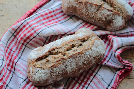 Wholemeal bread rolls on a kitchen towel