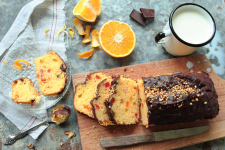 Cake with fruits and chocolate glaze with mug of fresh milkの写真素材