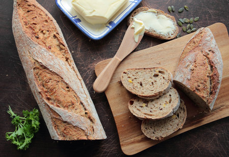 Bread sliced on wooden board with butter
