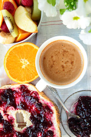 Roll with jam, sliced orange and coffee for breakfastの写真素材