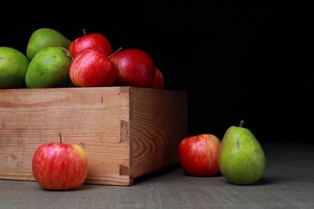 Juicy fruits in old wooden box. Red apples and green pears.の写真素材