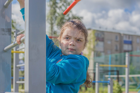 The girl does exercises at sports equipment