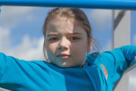 The girl does exercises at sports equipment