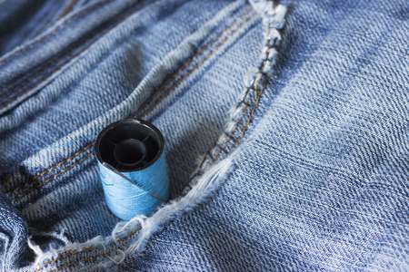 The spool of thread, needle, old jeansの写真素材