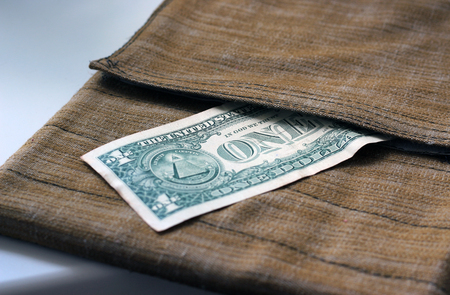 One dollar peeking out of surface-mounted pocket-bagsの写真素材