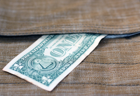 One dollar peeking out of surface-mounted pocket-bags