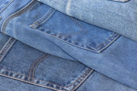 a few old denim pants lying nearbyの写真素材