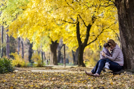 Mother and baby girl in the autumn forest