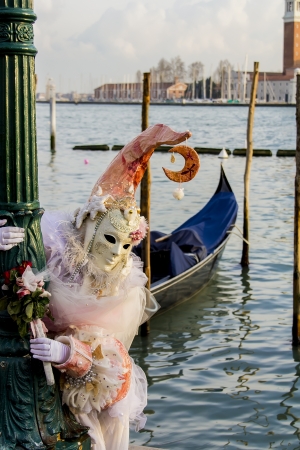 Venice, Italy, February 9, 2013: Unidentified person with traditional Venetian carnival mask in Venice, Italy at February 10, 2013. At 2013 it is held from January 26th to February 12th.のeditorial素材