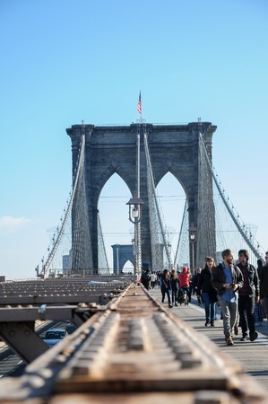 Unidentified people crossing the Brooklyn bridge in New York at November 24, 2011. Bridge was completed in 1883, and connects the boroughs of Manhattan and Brooklyn.のeditorial素材