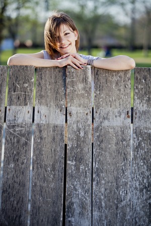 Young woman by the fenceの写真素材