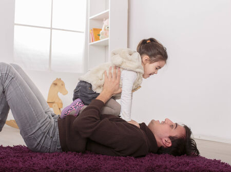 Father and daughter playing in the roomの写真素材