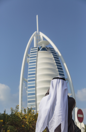 Dubai, UAE - January 16, 2014  Unidentified man taking photo of hotel Burj al Arab in Dubai  At 321 m, it is the fourth tallest hotel in the world and has 202 rooms のeditorial素材
