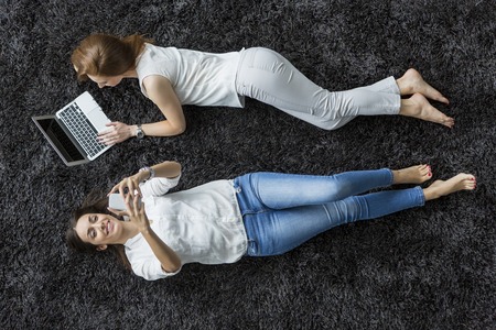 Young women relaxing on the carpetの写真素材
