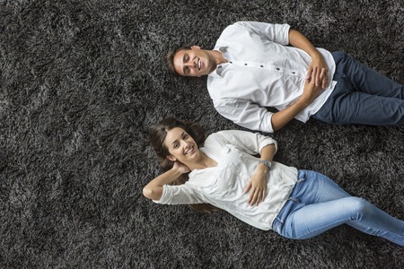 Young couple relaxing on the carpetの写真素材