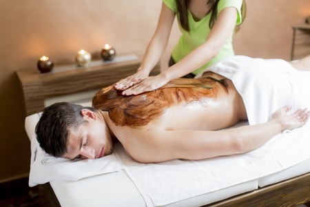 Young man having a chocolate massageの写真素材