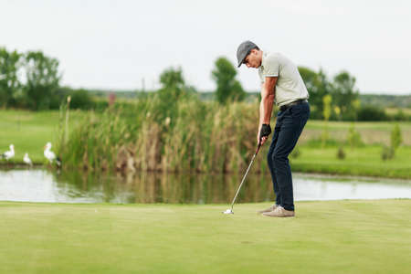 Young man playing golfの写真素材