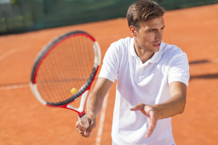 Young man playing tennisの写真素材