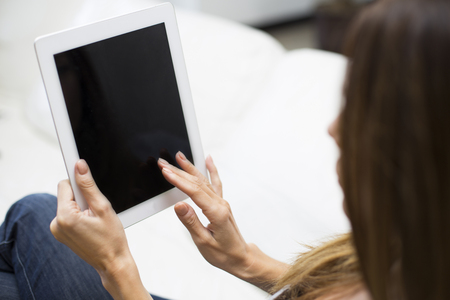 Young woman working with a tablet at homeの写真素材