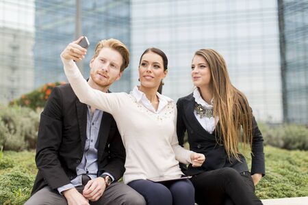 Young people taking photo with mobile phoneの写真素材