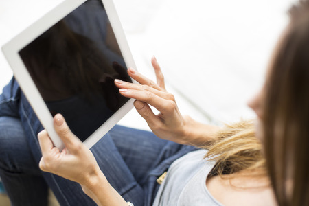 Young woman working with a tablet at homeの写真素材