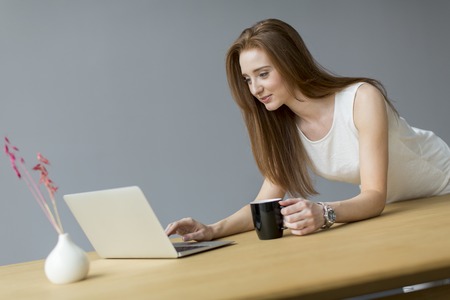 Young woman with laptop in the officeの写真素材