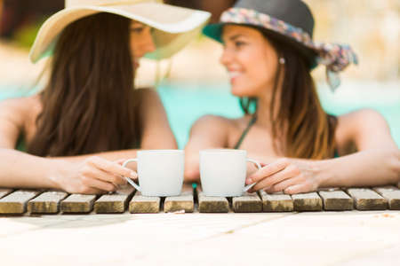 Young women relaxing in the poolの写真素材