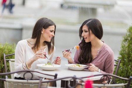Pretty young women having lunch in the restaurantの写真素材