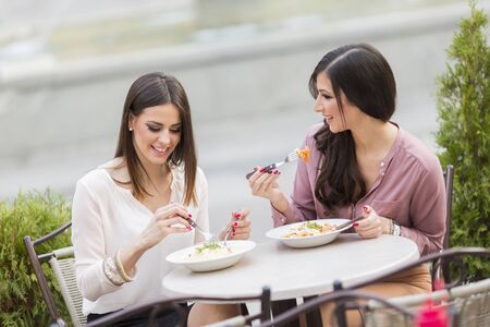 Pretty young women having lunch in the restaurantの写真素材