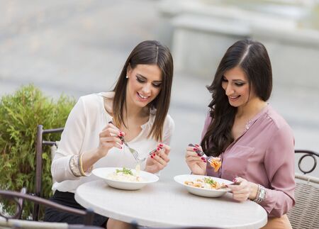 Pretty young women having lunch in the restaurantの写真素材