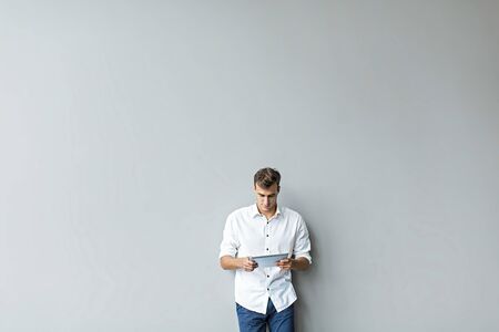 Man with tablet by the wallの写真素材