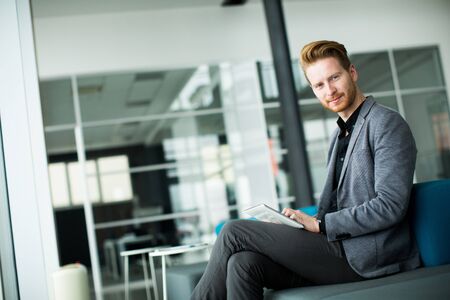 Young man with tablet in the officeの写真素材