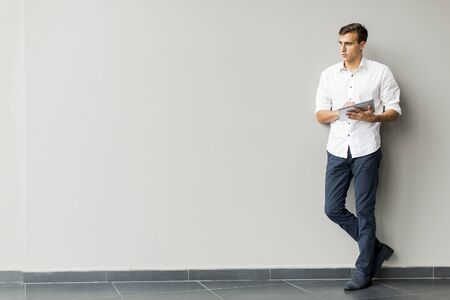Man with tablet by the wallの写真素材