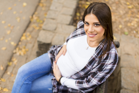 Young pregnant woman in the autumn parkの写真素材