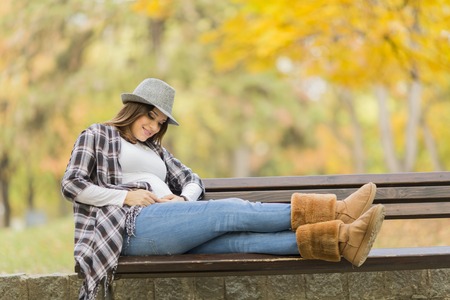 Young pregnant woman in the autumn parkの写真素材