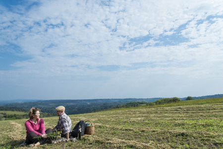 Senior couple sitting in the fieldの写真素材