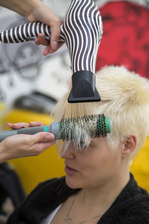 Young woman at hairdresser haircuttingの写真素材