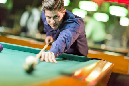 Young man playing poolの写真素材
