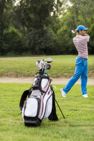 Young man playing golfの写真素材